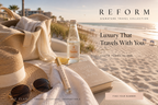 Lumiere No. 2 travel perfume pen on a beach towel beside a sun hat, sunglasses, book, and canvas bag.